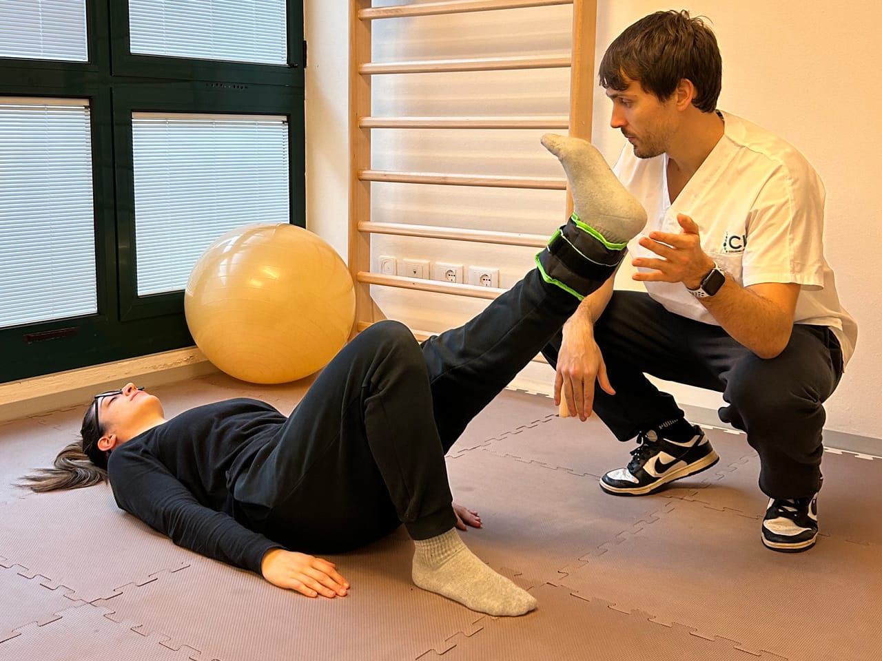 Fisioterapista a Scandiano conduce una seduta di rinforzo muscolare dell'arto inferiore per trattare debolezza muscolare, instabilità articolare, riabilitazione post-chirurgica e recupero funzionale dopo traumi